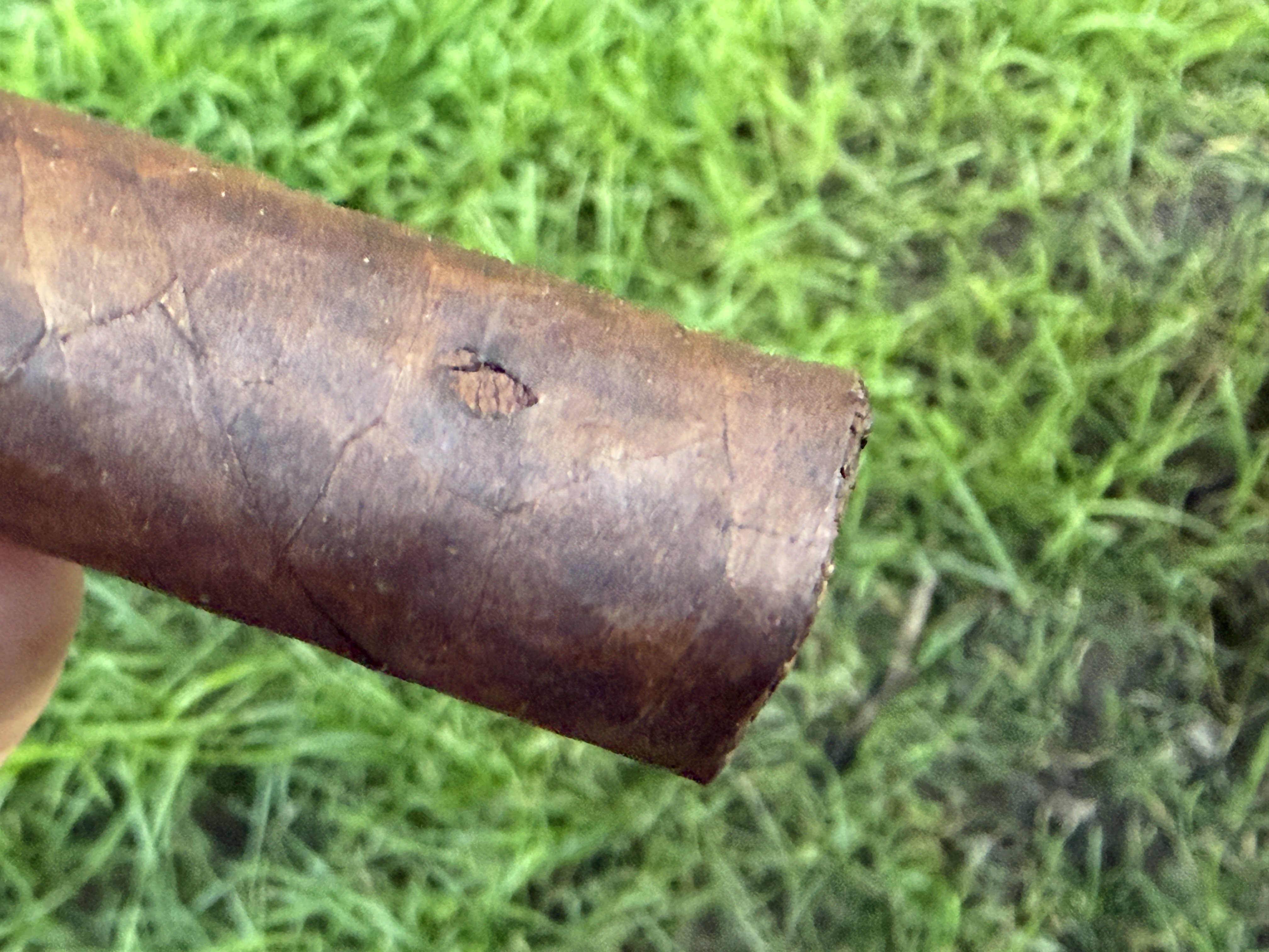 Close-up of the foot of the Mil Días Maduro showing a small hole in the wrapper leaf near the foot