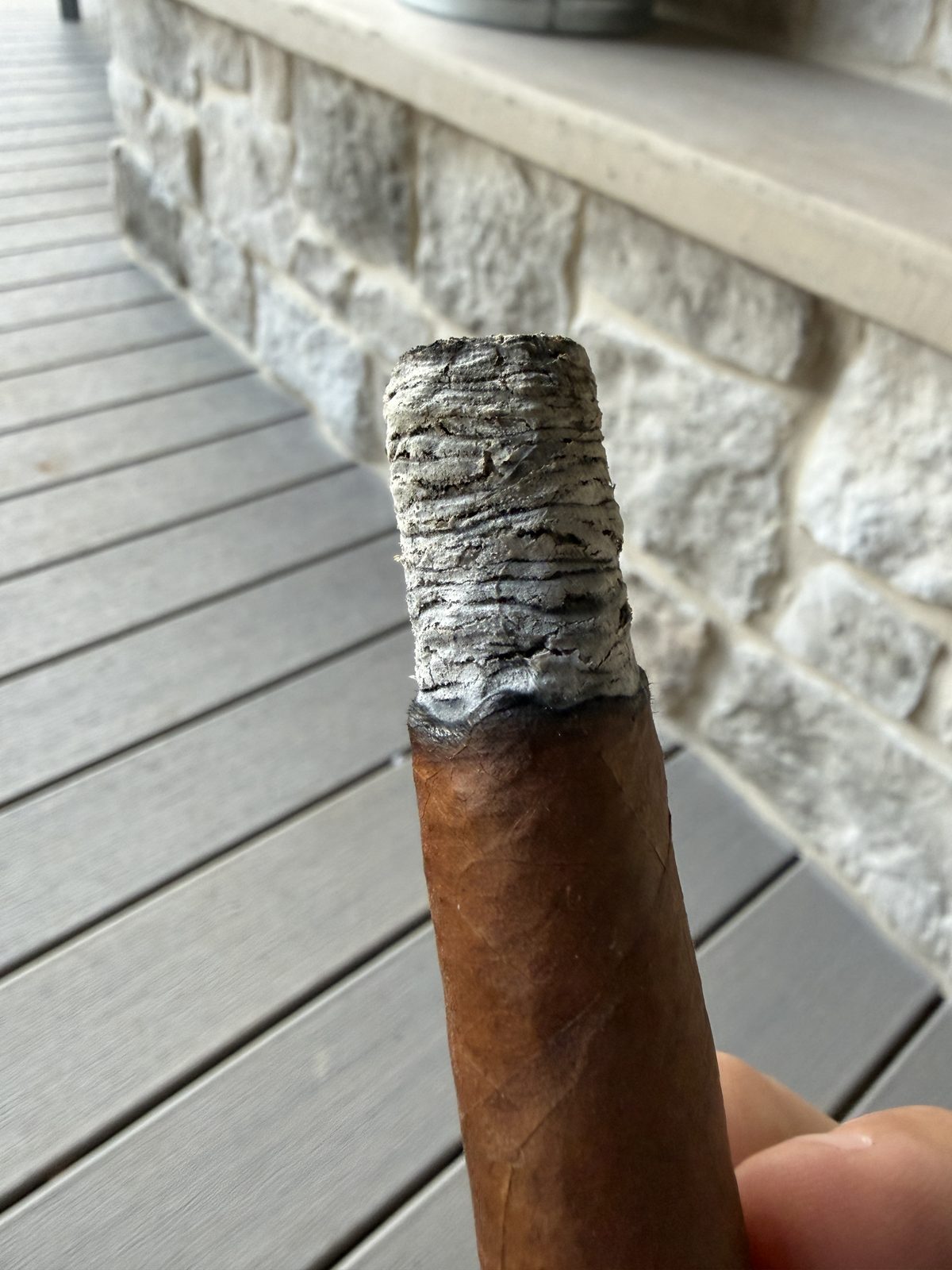 Tall stacked gray ash on the Crux Guild Toro, dime-stack ridges clearly visible