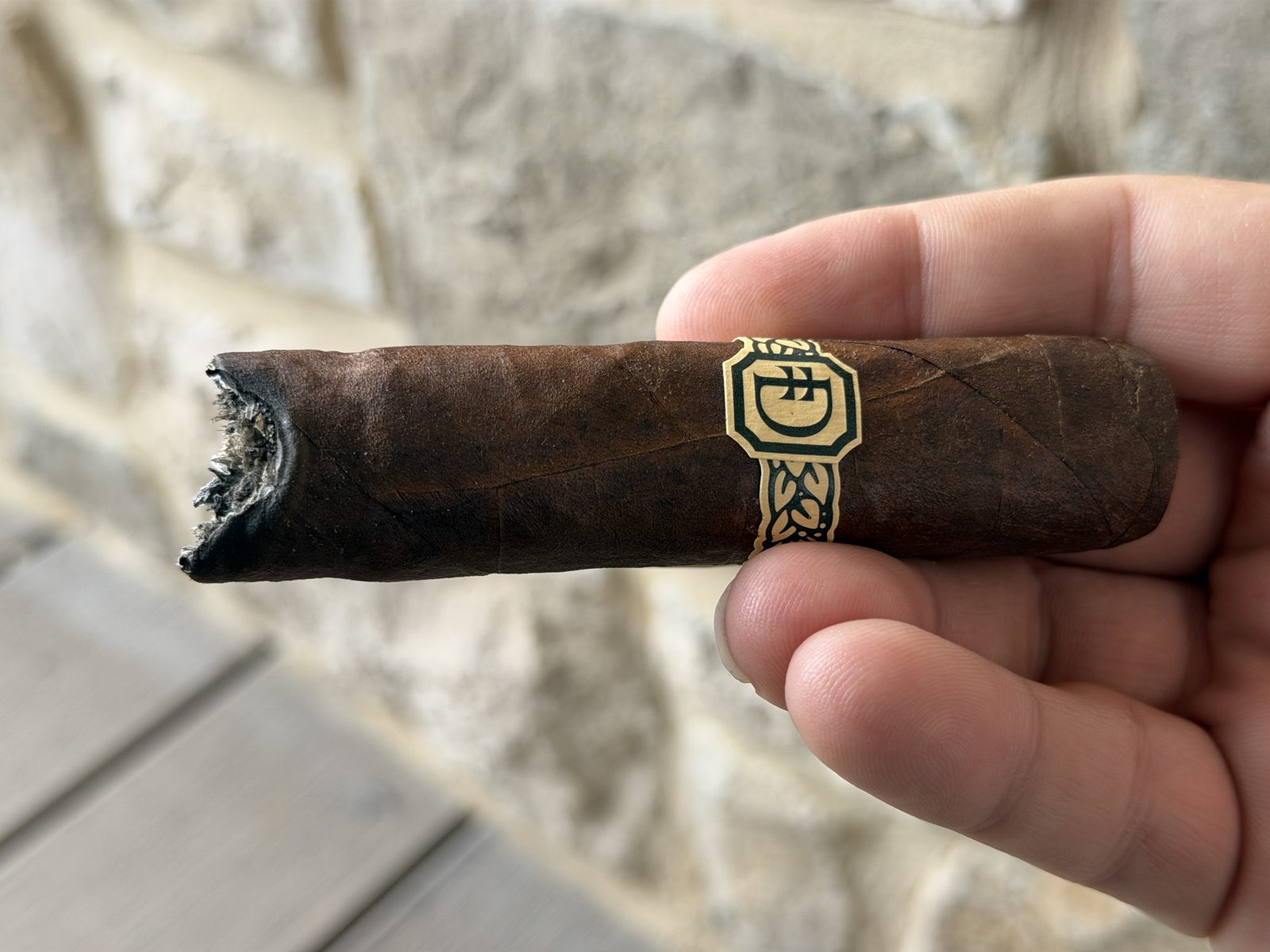 Dunbarton Sin Compromiso Seleccion No. 7 in hand after the ash fell off, the burn at the foot shaped like a horseshoe with one side trailing