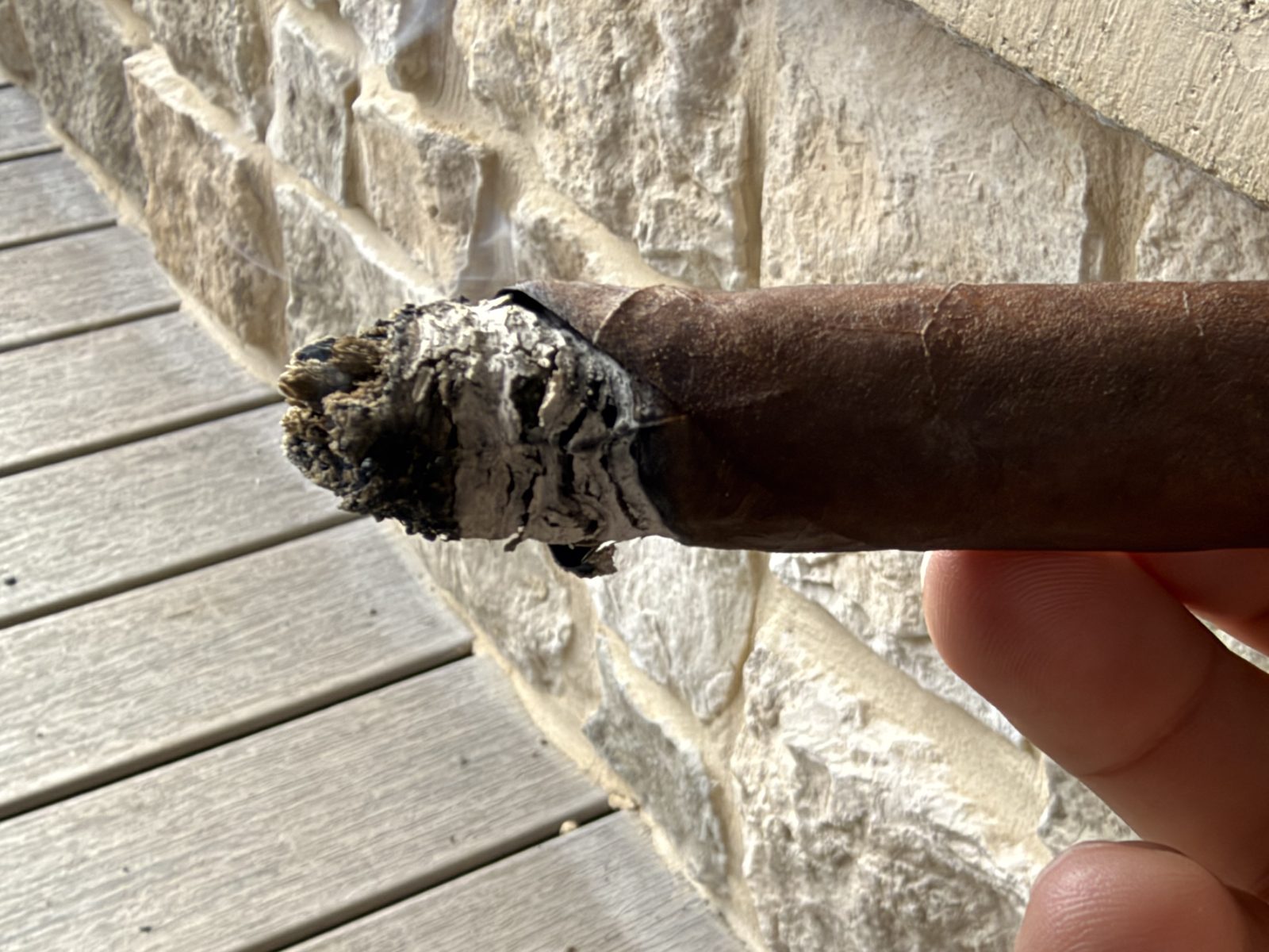 Close-up of the Dunbarton Sin Compromiso Seleccion No. 7 in the second third with a ragged, flaky gray ash and one side of the burn trailing well behind