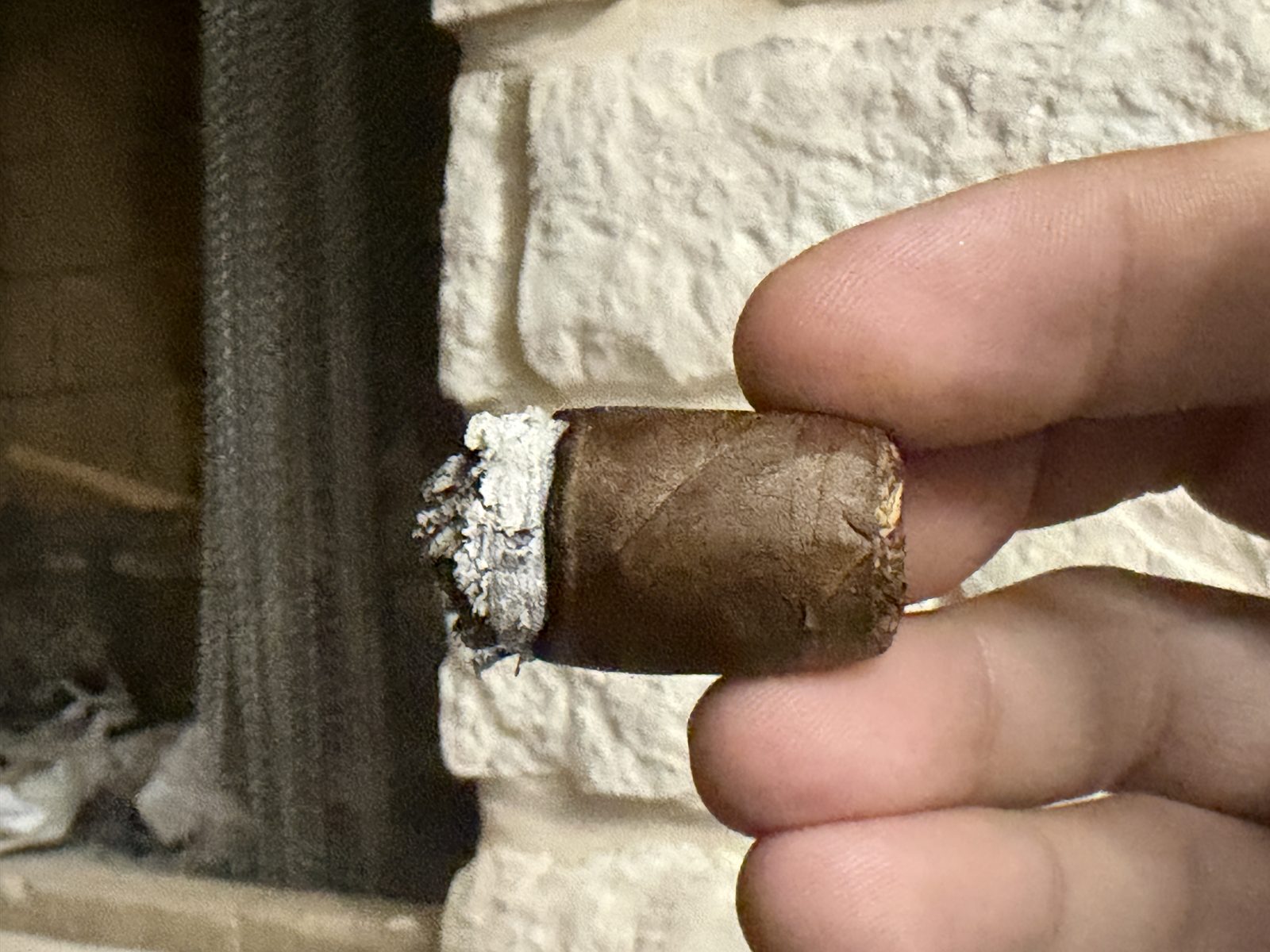 The nub of the Tabernacle 142 Toro held between two fingers, smoked down to the last inch