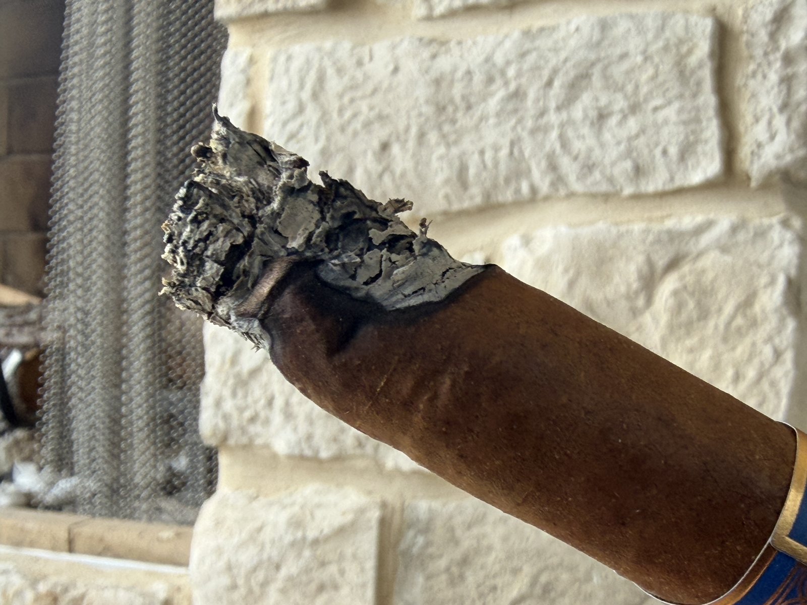 Close-up of the Wise Man Corojo showing a strip of unburned wrapper running up one side and a ragged ash