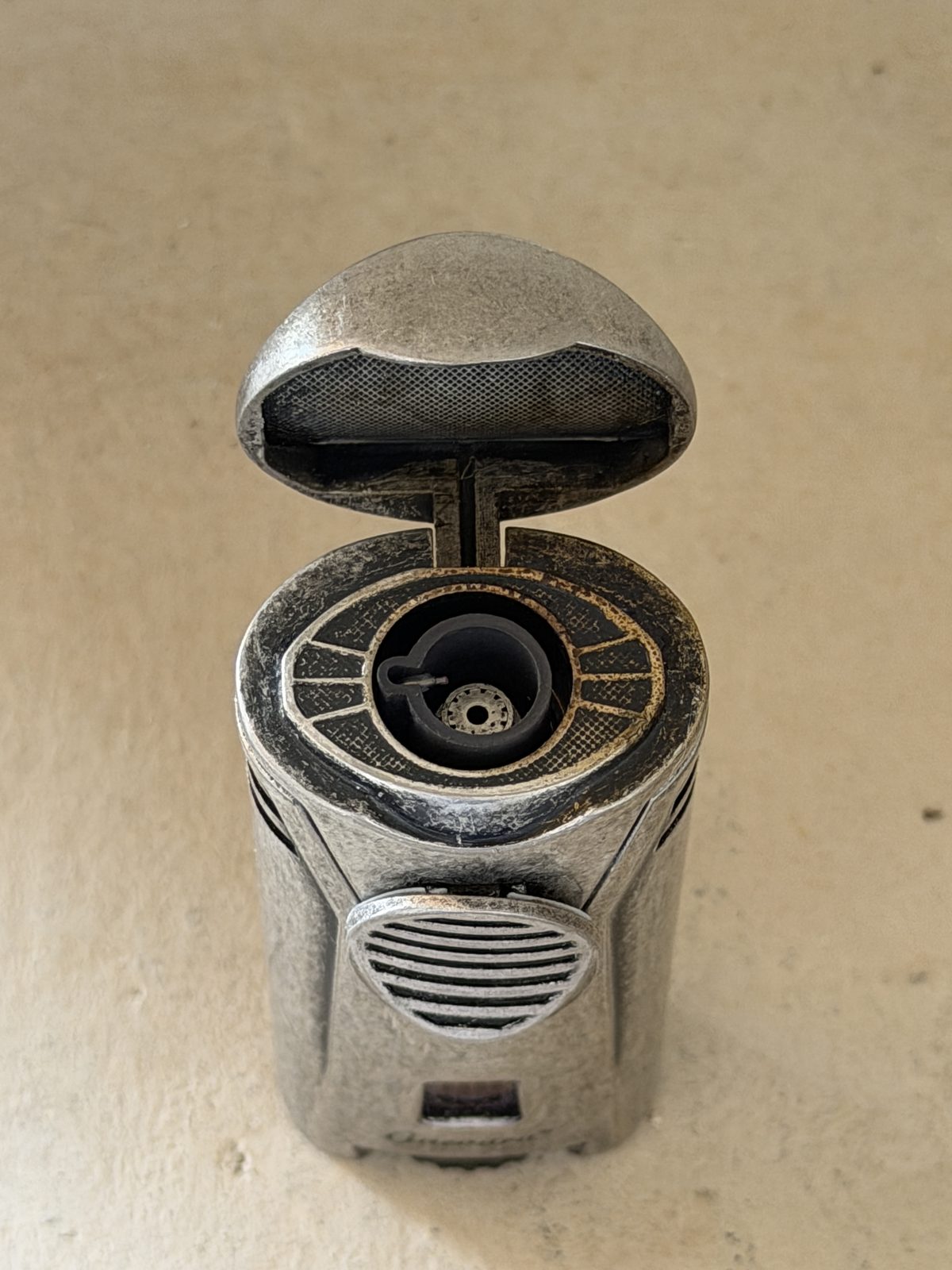 Guevara Lux lighter with the lid flipped open showing the single torch jet and heat marking around the burner