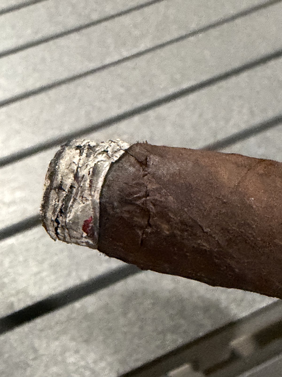 Close-up of the La Historia Doña Elena a few minutes after lighting, first ash forming and a crack in the wrapper running back from the burn line