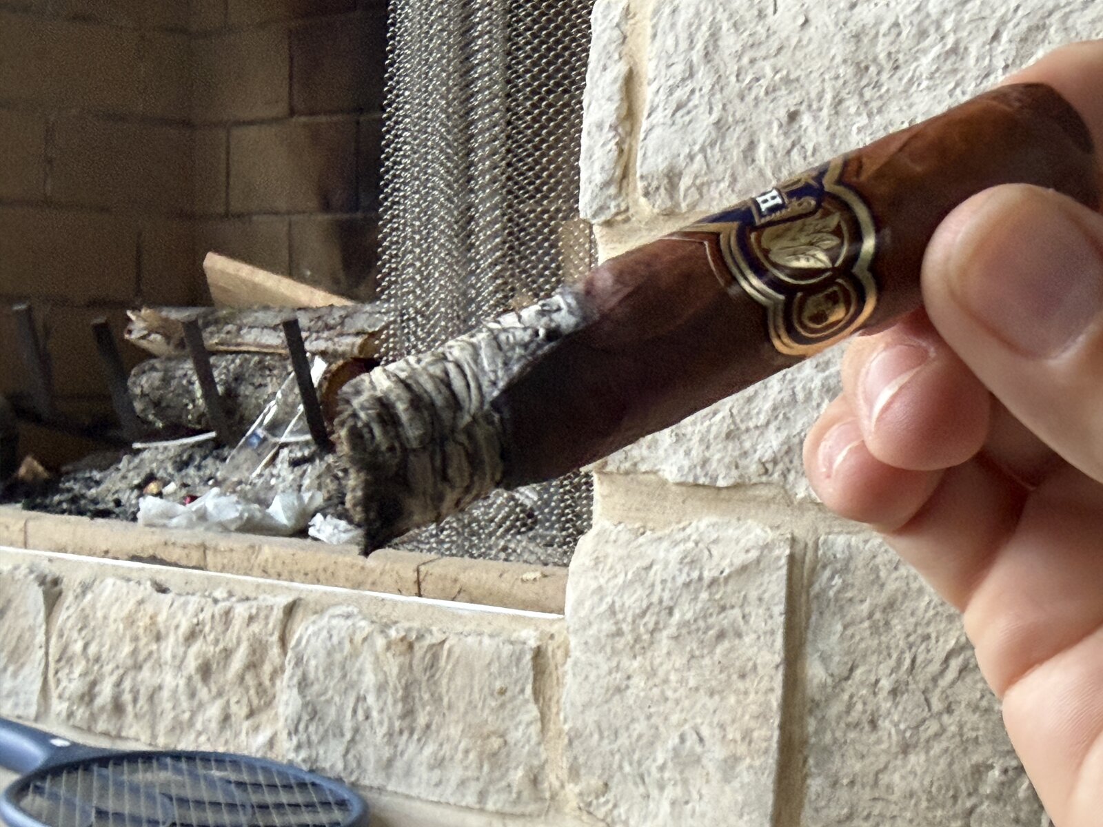 Mid-smoke Punch Reserve Collection Robusto showing an uneven, wavy burn line with tight gray ash