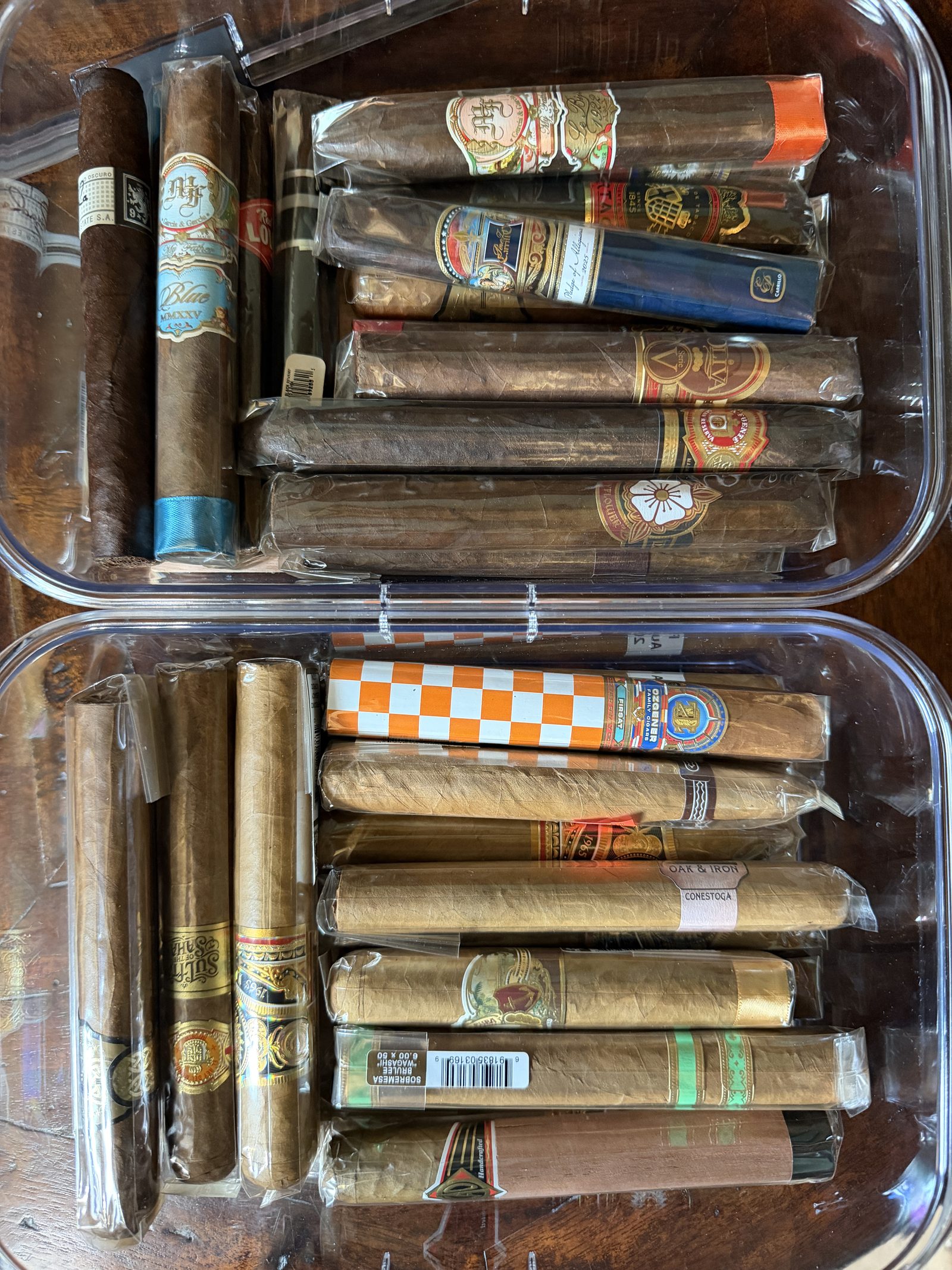 Two clear airtight containers packed with cigars, viewed from above