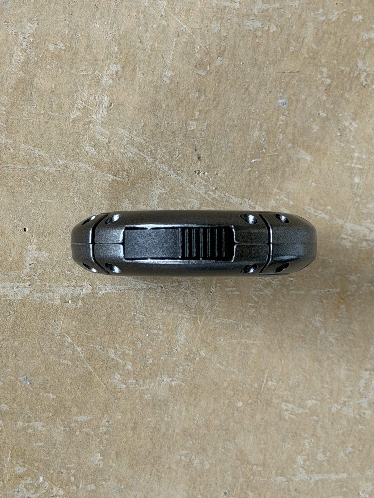 Edge-on profile of the closed Xikar XO showing body thickness and the release button